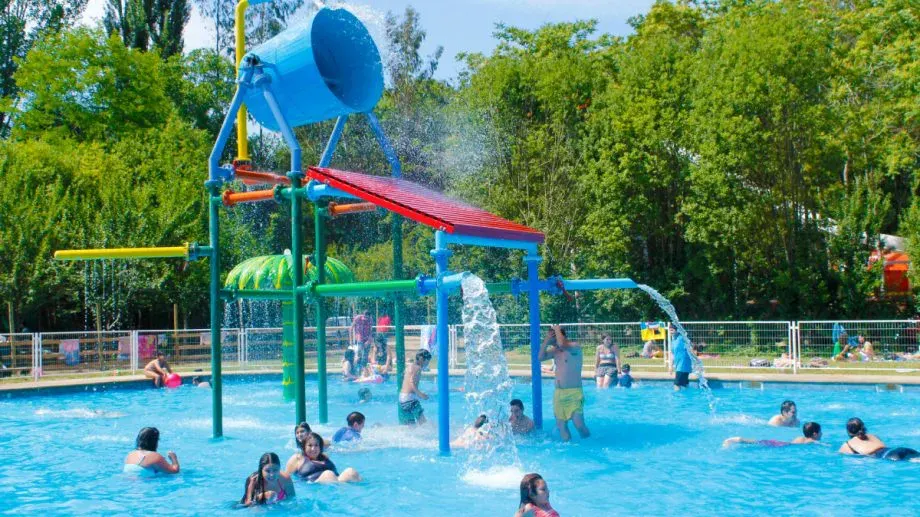Niños jugando en la zona de juegos acuáticos del parque