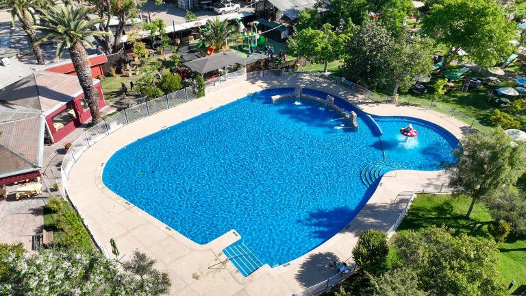 La piscina Aguas Salvajes rodeada de césped y árboles