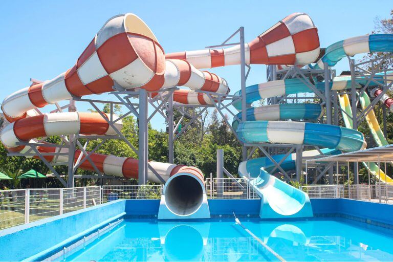 Los tubos rojos y blancos del tobogán Acuaspace sobre la piscina de llegada